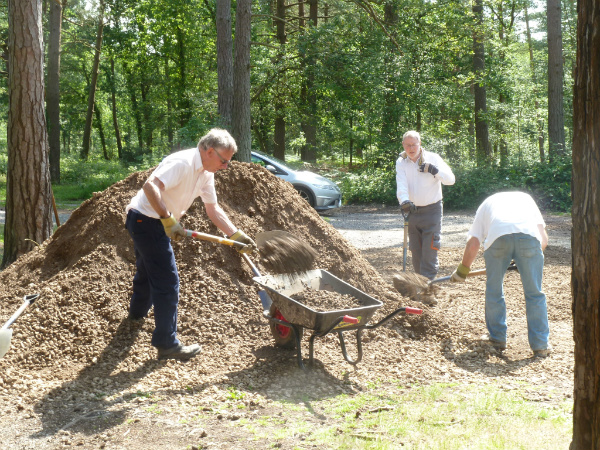 Volunteers load aggregate into wheelbarrows